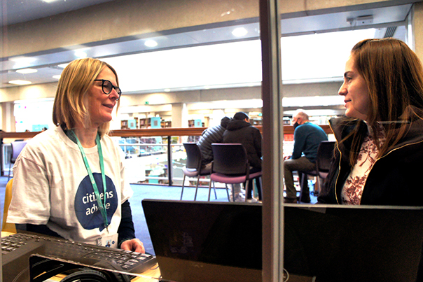 An adviser talks with client at the library drop-in advice session