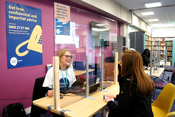 An adviser welcomes a client at the library drop-in advice session